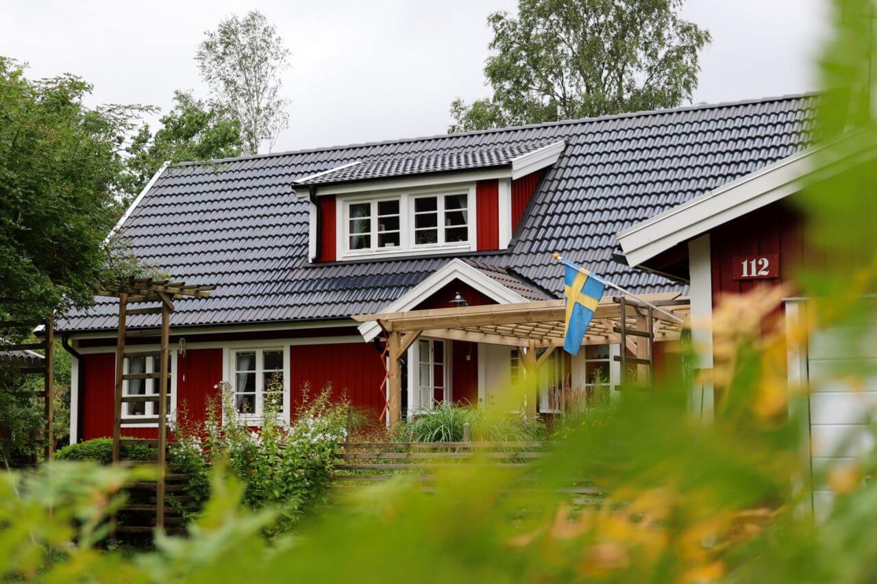 Helbild av ett rött hus med wave solceller på taket