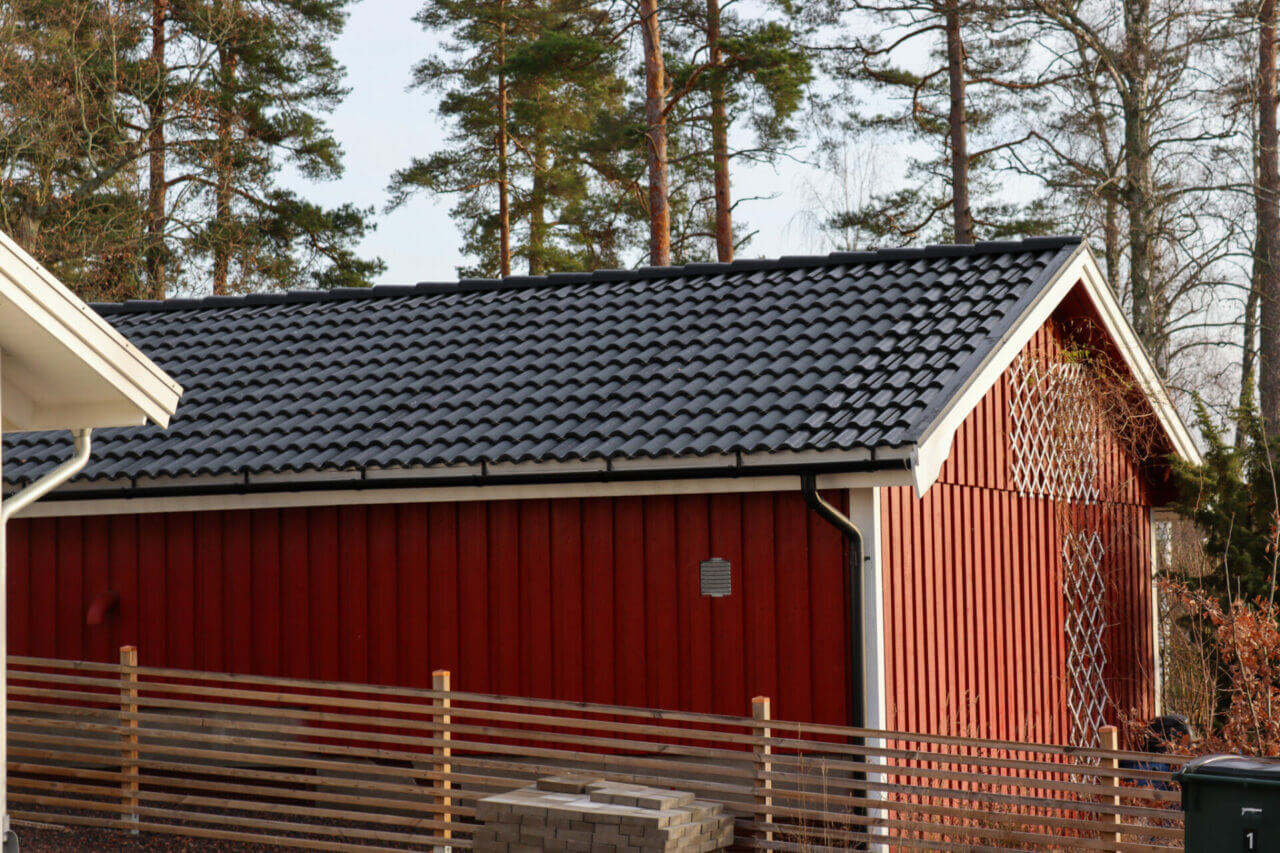Ett rött garage med wave solceller på taket